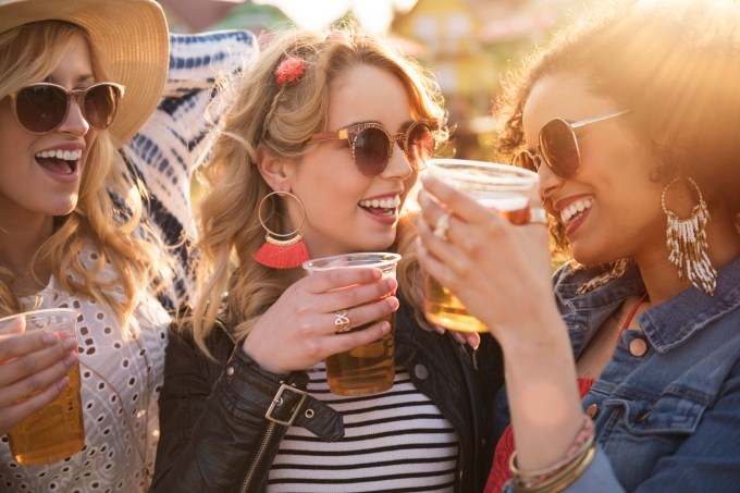 Mulheres brindam com copos de cerveja FOTO gpointstudio iStock-538879148