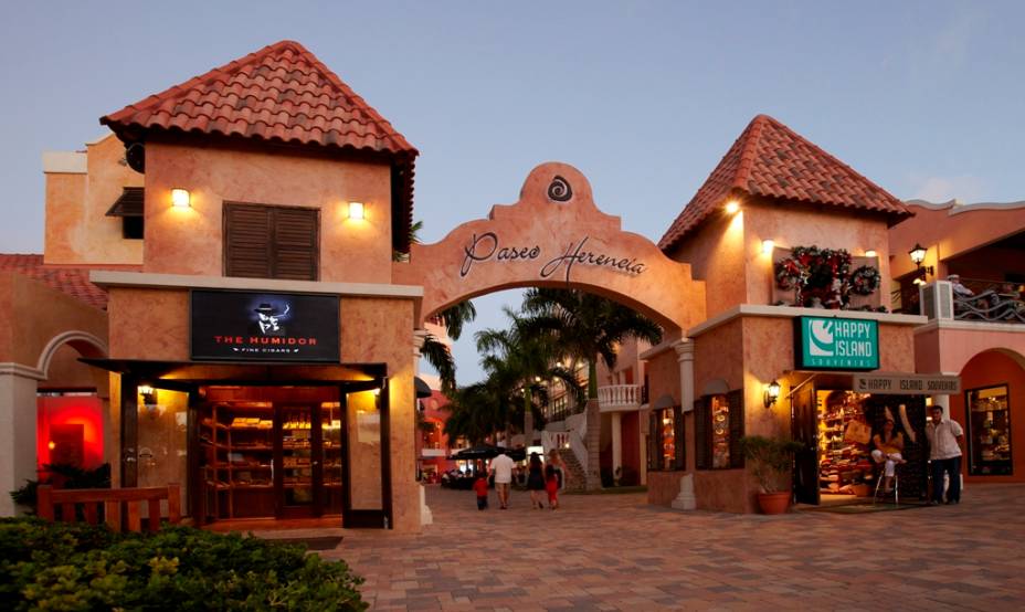 Boa parte das ilhas do <strong>Caribe </strong>depende do turismo para sobreviver. Algumas são paraísos fiscais usados para lavar dinheiro, outras foram abençoadas com importantes reservas de petróleo, mas são viajantes vindos em cruzeiros, barcos a vela e voos charters de todo mundo que sustentam parcela considerável da economia da região – e os empregos de muita gente. Como quase tudo por aqui tem que ser importado, foram criadas algumas zonas livres de impostos que beneficiam os viajantes, que terão à disposição algumas boas opções de compras em outlets e shoppings dos mais variados tamanhos. Roupas de grife, perfumes, tênis, bebidas e eletrônicos são só alguns dos artigos disponíveis em estabelecimentos como o <a href="https://www.paseoherencia.com/" target="_blank" rel="noopener">Paseo Herencia Mall </a>and<strong> Entertainment Center de Aruba</strong> (foto) e o <a href="https://www.kukulcanplaza.mx/" target="_blank" rel="noopener">Plaza Kukulcán</a> e <a href="https://www.laislacancun.mx/" target="_blank" rel="noopener">La Isla Shopping Village</a> de <strong>Cancún</strong>. Boa parte das ilhas do <strong>Caribe </strong>depende do turismo para sobreviver. Algumas são paraísos fiscais usados para lavar dinheiro, outras foram abençoadas com importantes reservas de petróleo, mas são viajantes vindos em cruzeiros, barcos a vela e voos charters de todo mundo que sustentam parcela considerável da economia da região – e os empregos de muita gente. Como quase tudo por aqui tem que ser importado, foram criadas algumas zonas livres de impostos que beneficiam os viajantes, que terão à disposição algumas boas opções de compras em outlets e shoppings dos mais variados tamanhos. Roupas de grife, perfumes, tênis, bebidas e eletrônicos são só alguns dos artigos disponíveis em estabelecimentos como o <a href="https://www.paseoherencia.com/" target="_blank" rel="noopener">Paseo Herencia Mall </a>and<strong> Entertainment Center de Aruba</strong> (foto) e o <a href="https://www.kukulcanplaza.mx/" target="_blank" rel="noopener">Plaza Kukulcán</a> e <a href="https://www.laislacancun.mx/" target="_blank" rel="noopener">La Isla Shopping Village</a> de <strong>Cancún</strong>.