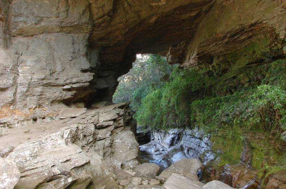 No extremo sul do <a href="https://viajeaqui.abril.com.br/estabelecimentos/br-mg-conceicao-do-ibitipoca-atracao-parque-estadual-do-ibitipoca" rel="Parque Estadual do Ibitipoca" target="_blank">Parque Estadual do Ibitipoca</a>, está a gruta Ponte de Pedra, uma espécie de viaduto rochoso sob o qual a umidade criou um espetacular forro de líquens, musgos e samambaias