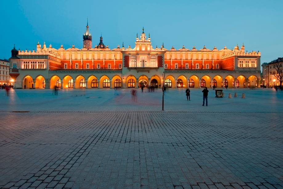 <strong>Praça do Mercado (Rynek Glówny) – <a href="https://preprod.viagemeturismo.abril.com.br/cidades/cracovia/" target="_blank" rel="noopener">Cracóvia</a> – <a href="https://preprod.viagemeturismo.abril.com.br/paises/polonia-2/" target="_blank" rel="noopener">Polônia</a></strong> O ponto focal de Cracóvia é sua grande Praça do Mercado. Em seu entorno encontram-se algumas das melhores opções de hospedagem da cidade, além de ótimos restaurantes, cafés e bares. Além disso, aqui estão o Sukiennice (Grande Salão das Guildas), à direita, onde hoje os turistas podem adquirir lembranças variadas, e a colorida e ricamente decorada Basílica de Santa Maria. Esta é a maior praça da Europa, declarada Patrimônio da Humanidade pela Unesco <em><a href="https://www.booking.com/searchresults.pt-br.html?aid=332455&sid=d98f25c4d6d5f89238aebe98e11a09ba&sb=1&src=searchresults&src_elem=sb&error_url=https%3A%2F%2Fwww.booking.com%2Fsearchresults.pt-br.html%3Faid%3D332455%3Bsid%3Dd98f25c4d6d5f89238aebe98e11a09ba%3Btmpl%3Dsearchresults%3Bac_click_type%3Db%3Bac_position%3D0%3Bcity%3D-129709%3Bclass_interval%3D1%3Bdest_id%3D-345275%3Bdest_type%3Dcity%3Bdtdisc%3D0%3Bfrom_sf%3D1%3Bgroup_adults%3D2%3Bgroup_children%3D0%3Biata%3DCUZ%3Binac%3D0%3Bindex_postcard%3D0%3Blabel_click%3Dundef%3Bno_rooms%3D1%3Boffset%3D0%3Bpostcard%3D0%3Braw_dest_type%3Dcity%3Broom1%3DA%252CA%3Bsb_price_type%3Dtotal%3Bsearch_selected%3D1%3Bshw_aparth%3D1%3Bslp_r_match%3D0%3Bsrc%3Dsearchresults%3Bsrc_elem%3Dsb%3Bsrpvid%3D18f97cc4163f00ab%3Bss%3DCusco%252C%2520Cusco%252C%2520Peru%3Bss_all%3D0%3Bss_raw%3Dcusco%3Bssb%3Dempty%3Bsshis%3D0%3Bssne%3DSiena%3Bssne_untouched%3DSiena%26%3B&ss=Crac%C3%B3via%2C+Lesser+Poland%2C+Pol%C3%B4nia&is_ski_area=&ssne=Cusco&ssne_untouched=Cusco&city=-345275&checkin_year=&checkin_month=&checkout_year=&checkout_month=&group_adults=2&group_children=0&no_rooms=1&from_sf=1&ss_raw=crac%C3%B3via&ac_position=0&ac_langcode=xb&ac_click_type=b&dest_id=-510625&dest_type=city&iata=KRK&place_id_lat=50.063&place_id_lon=19.937&search_pageview_id=18f97cc4163f00ab&search_selected=true&search_pageview_id=18f97cc4163f00ab&ac_suggestion_list_length=5&ac_suggestion_theme_list_length=0" target="_blank" rel="noopener">Busque hospedagem em Cracóvia</a> </em>
