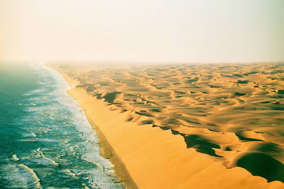 Um deserto imenso, com dunas de areia fofa que vão avançando Oceano Atlântico adentro – em mais ou menos 15 metros por ano. Com um nome que evoca os lugares assustadores dos filmes de pirata, a Costa do Esqueleto, na Namíbia, é mesmo intrigante. Quem encara o areião em um carro 4x4 ou sobrevoa a região topa com um conjunto de estranhezas. Encontra um monte de naufrágios (estima-se que são mais de mil barcos e grandes navios que, ao longo dos séculos, se estreparam ao chegar perto das dunas submersas). Avista minas de diamante, muitas desativadas por causa das condições extremas. Vê ossos de baleia. E passa perto de esqueletos de náufragos ou de pescadores. Pois é... Um deserto imenso, com dunas de areia fofa que vão avançando Oceano Atlântico adentro – em mais ou menos 15 metros por ano. Com um nome que evoca os lugares assustadores dos filmes de pirata, a Costa do Esqueleto, na Namíbia, é mesmo intrigante. Quem encara o areião em um carro 4x4 ou sobrevoa a região topa com um conjunto de estranhezas. Encontra um monte de naufrágios (estima-se que são mais de mil barcos e grandes navios que, ao longo dos séculos, se estreparam ao chegar perto das dunas submersas). Avista minas de diamante, muitas desativadas por causa das condições extremas. Vê ossos de baleia. E passa perto de esqueletos de náufragos ou de pescadores. Pois é...