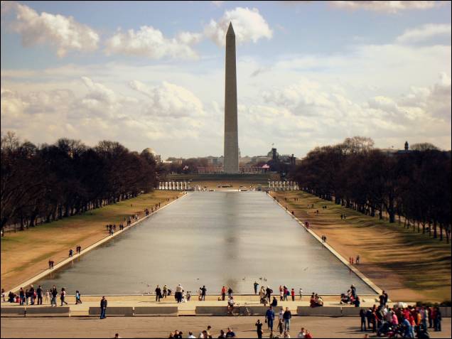 O <strong>Obelisco</strong> da vida real, cercado de visitantes numa tarde ensolarada e tranquila O <strong>Obelisco</strong> da vida real, cercado de visitantes numa tarde ensolarada e tranquila