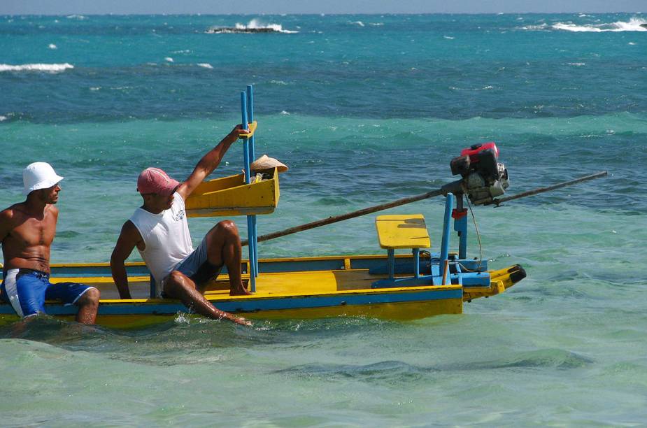 De vez em quando, pescadores aparecem em seus barquinhos para recolher o ganha-pão