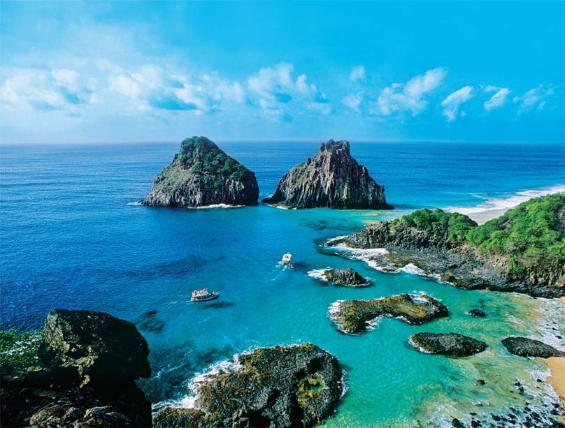 O mais belo conjunto de praias do Brasil fica aqui, em<strong> Fernando de Noronha</strong>. A visão clássica do arquipélago pernambucano, localizado a 345 quilômetros da costa, é a da Baía dos Porcos, com o morro Dois Irmãos despontando do mar azul O mais belo conjunto de praias do Brasil fica aqui, em<strong> Fernando de Noronha</strong>. A visão clássica do arquipélago pernambucano, localizado a 345 quilômetros da costa, é a da Baía dos Porcos, com o morro Dois Irmãos despontando do mar azul