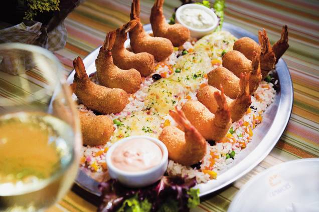 Camarão Ponta Negra, empanado e recheado com queijo catupiry, servido com molho tártaro e rosê, acompanhado por arroz à grega e batata gratinada. Essa delícia é do restaurante <a href="https://viajeaqui.abril.com.br/estabelecimentos/br-rn-natal-restaurante-camaroes-potiguar" rel="Camarões">Camarões</a>, em Natal (RN). A casa é muito frequentada por turistas e é famosa por seus pratos bem servidos. Camarão Ponta Negra, empanado e recheado com queijo catupiry, servido com molho tártaro e rosê, acompanhado por arroz à grega e batata gratinada. Essa delícia é do restaurante <a href="https://viajeaqui.abril.com.br/estabelecimentos/br-rn-natal-restaurante-camaroes-potiguar" rel="Camarões">Camarões</a>, em Natal (RN). A casa é muito frequentada por turistas e é famosa por seus pratos bem servidos.