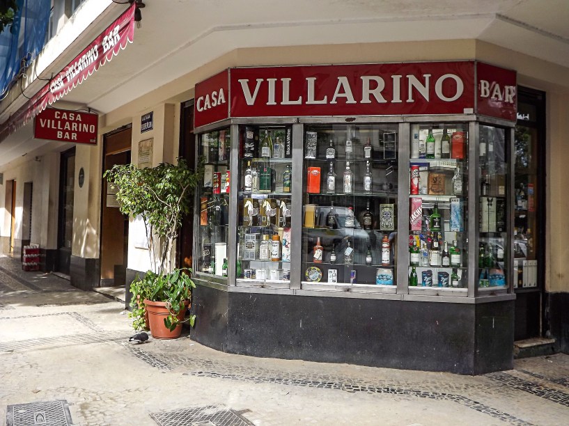 <strong>PARA CURTIR O CENTRO E ARREDORES</strong> <strong><a href="https://www.villarino.com.br/" target="_blank" rel="noopener">Casa Villarino</a> </strong>Um painel fotográfico nos fundos do salão registra um encontro que marcou a história da música brasileira. Inaugurado em 1953, este misto de delicatessen e bar foi o cenário, três anos depois, do convite de Vinicius de Moraes a Tom Jobim para musicar a peça Orfeu da Conceição, dando início a uma longa parceria. A aura do passado ainda resiste no ambiente escurinho e demodê, com piso de ladrilho e mesas com tampo de mármore. A casa só funciona de segunda a sexta (até 21h) e não serve chope. Cerveja e doses de uísque escoltam porções de frios e sanduíches de rosbife ou carne assada. Dica: aproveite para casar uma visita (agendada) à <a href="https://viajeaqui.abril.com.br/estabelecimentos/br-rj-rio-de-janeiro-atracao-academia-brasileira-de-letras" target="_blank" rel="noopener">Academia Brasileira de Letras</a>, que fica pertinho dali <em>Av. Calógeras, 6 (Centro), (21) 2240-1627</em>