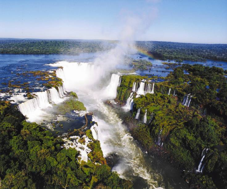 As <a href="https://preprod.viagemeturismo.abril.com.br/atracao/parque-nacional-do-iguacu-brasil/"><strong>Cataratas do Iguaçu</strong></a> são um dos <a href="https://preprod.viagemeturismo.abril.com.br/materias/os-7-patrimonios-naturais-da-unesco-no-brasil/">Patrimônios Naturais da Unesco no Brasil</a> e um dos cartões postais mais famosos do país. Com 275 quedas, tem o título de maior queda d’água em volume do mundo. O lado brasileiro, em <a href="https://preprod.viagemeturismo.abril.com.br/cidades/foz-do-iguacu/" target="_blank"><strong>Foz do Iguaçu</strong></a>, no <a href="https://preprod.viagemeturismo.abril.com.br/estados/parana/" target="_blank"><strong>Paraná</strong></a>, proporciona uma bela visão, enquanto o argentino impressiona pela força e pela proximidade da Garganta do Diabo