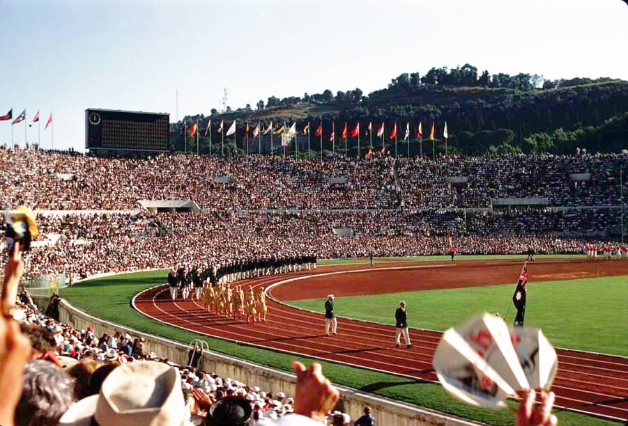 <strong>14. <a href="https://viajeaqui.abril.com.br/cidades/italia-roma" target="_blank" rel="noopener">Roma</a>, <a href="https://viajeaqui.abril.com.br/paises/italia" target="_blank" rel="noopener">Itália</a>, 1960</strong> Lá em 1908, Roma tinha perdido a oportunidade de sediar as Olimpíadas por causa da erupção do vulcão Vesúvio. Depois de 52 anos, o tão esperado momento chegou com a cerimônia de abertura (foto), em 25 de agosto. Toda a competição foi marcada pela utilização de pontos turísticos que remetiam à Roma Antiga para o transcorrer das modalidades esportivas, como o Arco e a Basílica de Constantino, as Termas de Caracala e as ruínas do Foro Romano.