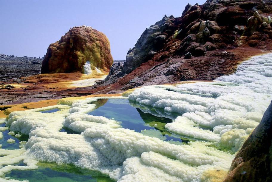 <strong>Dallol, Etiópia</strong> O vulcão Dallol e as áreas adjacentes são uma filial do inferno. Aqui as temperaturas estão quase que permanentemente na altura dos 40 graus, os vapores dos gêiseres são venenosos e os jatos de gêiseres são ácidos. Vulcano e Hades se sentiriam em casa por aqui. <a href="https://www.booking.com/searchresults.pt-br.html?aid=332455&lang=pt-br&sid=eedbe6de09e709d664615ac6f1b39a5d&sb=1&src=searchresults&src_elem=sb&error_url=https%3A%2F%2Fwww.booking.com%2Fsearchresults.pt-br.html%3Faid%3D332455%3Bsid%3Deedbe6de09e709d664615ac6f1b39a5d%3Bcity%3D-2601889%3Bclass_interval%3D1%3Bdest_id%3D146%3Bdest_type%3Dcountry%3Bdtdisc%3D0%3Bfrom_sf%3D1%3Bgroup_adults%3D2%3Bgroup_children%3D0%3Binac%3D0%3Bindex_postcard%3D0%3Blabel_click%3Dundef%3Bno_rooms%3D1%3Boffset%3D0%3Bpostcard%3D0%3Braw_dest_type%3Dcountry%3Broom1%3DA%252CA%3Bsb_price_type%3Dtotal%3Bsearch_selected%3D1%3Bsrc%3Dsearchresults%3Bsrc_elem%3Dsb%3Bss%3DNam%25C3%25ADbia%3Bss_all%3D0%3Bss_raw%3DNam%25C3%25ADbia%3Bssb%3Dempty%3Bsshis%3D0%3Bssne_untouched%3DLondres%26%3B&ss=Eti%C3%B3pia&ssne=Nam%C3%ADbia&ssne_untouched=Nam%C3%ADbia&checkin_monthday=&checkin_month=&checkin_year=&checkout_monthday=&checkout_month=&checkout_year=&no_rooms=1&group_adults=2&group_children=0&highlighted_hotels=&from_sf=1&ss_raw=Eti%C3%B3pia+&ac_position=0&ac_langcode=xb&dest_id=68&dest_type=country&search_pageview_id=29e277c2ef2b02e1&search_selected=true&search_pageview_id=29e277c2ef2b02e1&ac_suggestion_list_length=1&ac_suggestion_theme_list_length=0" target="_blank" rel="noopener"><em>Busque hospedagens na Etiópia no Booking.com</em></a>