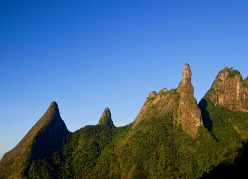 <strong>19. Parque Nacional da Serra dos Órgãos</strong>Teresópolis abriga a sede mais estruturada do parque (Petrópolis e Guapimirim são as outras entradas), que tem como símbolo o <strong>Pico Dedo de Deus </strong><em>(foto)</em>, a 1692 metros de altitude. O ideal é contratar um <a href="https://icmbio.gov.br" rel="guia credenciado" target="_blank">guia credenciado</a> para caminhadas mais pesadas, caso do trajeto de 11 quilômetros até a Pedra do Sino. Avenida Rotariana, s/n°, Alto, 21/2152-1100.