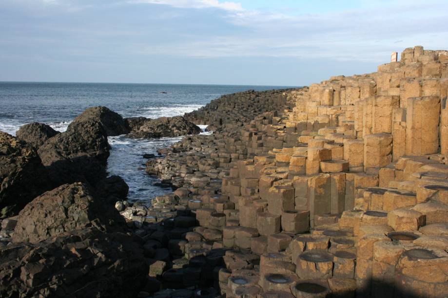 <strong>Giants Causeway, Irlanda do Norte</strong> A curiosa formação que deu origem à lenda do gigante nada mais é que um conjunto de colunas de basalto. É a atração número 1 da Irlanda do Norte. <em><a href="https://www.booking.com/searchresults.pt-br.html?aid=332455&lang=pt-br&sid=eedbe6de09e709d664615ac6f1b39a5d&sb=1&src=index&src_elem=sb&error_url=https%3A%2F%2Fwww.booking.com%2Findex.pt-br.html%3Faid%3D332455%3Bsid%3Deedbe6de09e709d664615ac6f1b39a5d%3Bsb_price_type%3Dtotal%26%3B&ss=Irlanda+do+Norte%2C+%E2%80%8BReino+Unido&checkin_monthday=&checkin_month=&checkin_year=&checkout_monthday=&checkout_month=&checkout_year=&no_rooms=1&group_adults=2&group_children=0&from_sf=1&ss_raw=Irlanda+do+Norte+&ac_position=0&ac_langcode=xb&dest_id=1114&dest_type=region&search_pageview_id=b78a7774475204af&search_selected=true&search_pageview_id=b78a7774475204af&ac_suggestion_list_length=2&ac_suggestion_theme_list_length=0&district_sel=0&airport_sel=0&landmark_sel=0&map=1" target="_blank" rel="noopener">Busque hospedagens na Irlanda do Norte no Booking.com</a></em>