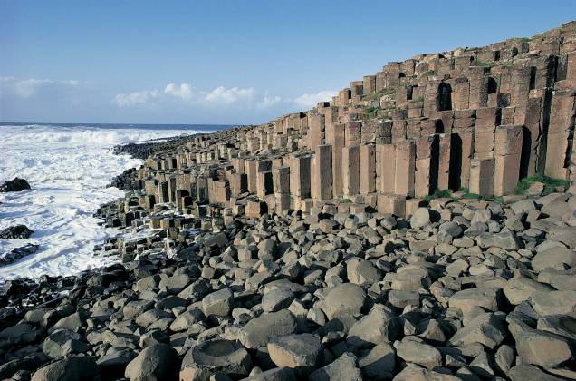 Localizada no condado de Antrim, na Irlanda do Norte, a Giants Causeway (em português, Calçada do Gigante) forma um conjunto de colunas prismáticas que formam um cenário peculiar Localizada no condado de Antrim, na Irlanda do Norte, a Giants Causeway (em português, Calçada do Gigante) forma um conjunto de colunas prismáticas que formam um cenário peculiar