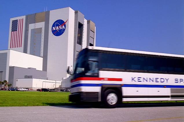 Ônibus do tour do Kennedy Space Center estão inclusos no preço da entrada do parque e passam pelo prédio que monta os veículos espaciais da Nasa Ônibus do tour do Kennedy Space Center estão inclusos no preço da entrada do parque e passam pelo prédio que monta os veículos espaciais da Nasa