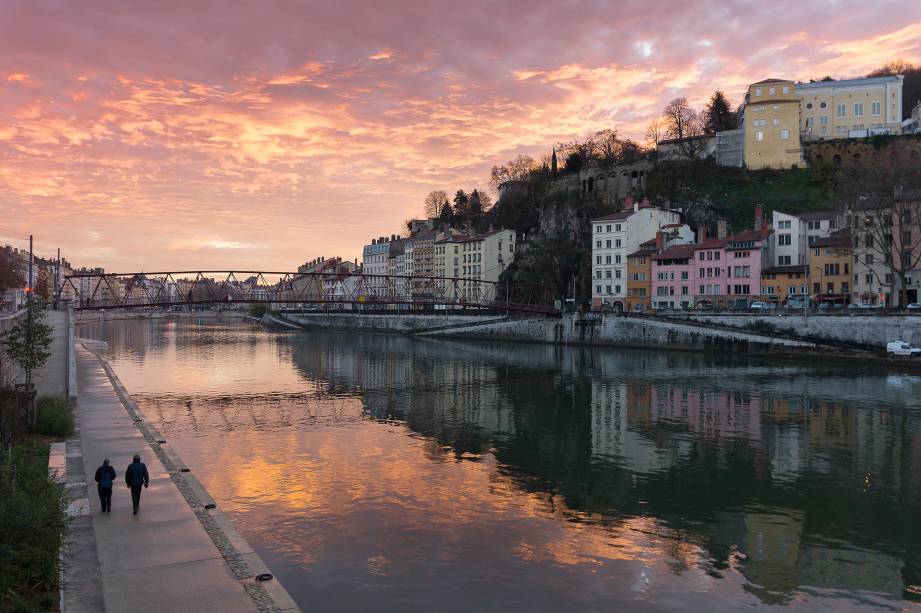 O dia amanhece à beira de um dos rios que cruza a cidade de <a href="https://viajeaqui.abril.com.br/cidades/franca-lyon" rel="Lyon" target="_blank">Lyon</a>, na <a href="https://viajeaqui.abril.com.br/paises/franca" rel="França" target="_blank">França</a>