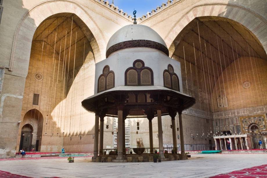 A madrassa (escola islâmica) desta mesquita é uma das mais antigas e importantes do mundo, especialmente para os sunitas, pois nela são ensinadas as quatro escolas sunitas de pensamento: Shafi’i, Maliki, Hanafi e Hanbali. A construção desta casa de orações começou em 1356 e foi tão instável quanto o governo do Sultão Hassan. Projetada para ter 4 minaretes, o que ficava logo acima da entrada caiu e matou cerca de 300 pessoas. Pouco depois do acidente, o sultão foi assassinado e as obras da mesquita, que já duravam 3 anos e custaram muito dinheiro, foram rapidamente encerradas. Outro minarete caiu em 1659, assim como a cúpula, que era de madeira. A cúpula e minaretes restantes foram restaurados e agora parece que não cai mais nada. A Mesquita Sultão Hassan é a única de estilo mameluco a ser decorada com cerâmica e sua madrassa é considerada uma das mais antigas universidades do mundo