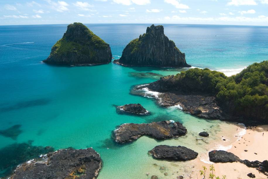 <a href="https://viajeaqui.abril.com.br/estabelecimentos/br-pe-fernando-de-noronha-atracao-praia-da-baia-dos-porcos"><b>Praia da Baía dos Porcos</b></a>A praia é pequena, com apenas 100 metros de extensão, mas veja a foto acima: ela justifica a fama, mas não diz tudo, pois a beleza dela está também nas piscinas naturais que se formam na maré baixa. Leve o snorkel e tome cuidado com as pedras escorregadias. A partir do mirante, faça uma foto clássica sua, com o Morro Dois Irmãos ao fundo. Acredite nos seus olhos e sorria, você está em Noronha. <a href="https://viajeaqui.abril.com.br/estabelecimentos/br-pe-fernando-de-noronha-atracao-praia-da-baia-dos-porcos"><b>Praia da Baía dos Porcos</b></a>A praia é pequena, com apenas 100 metros de extensão, mas veja a foto acima: ela justifica a fama, mas não diz tudo, pois a beleza dela está também nas piscinas naturais que se formam na maré baixa. Leve o snorkel e tome cuidado com as pedras escorregadias. A partir do mirante, faça uma foto clássica sua, com o Morro Dois Irmãos ao fundo. Acredite nos seus olhos e sorria, você está em Noronha.