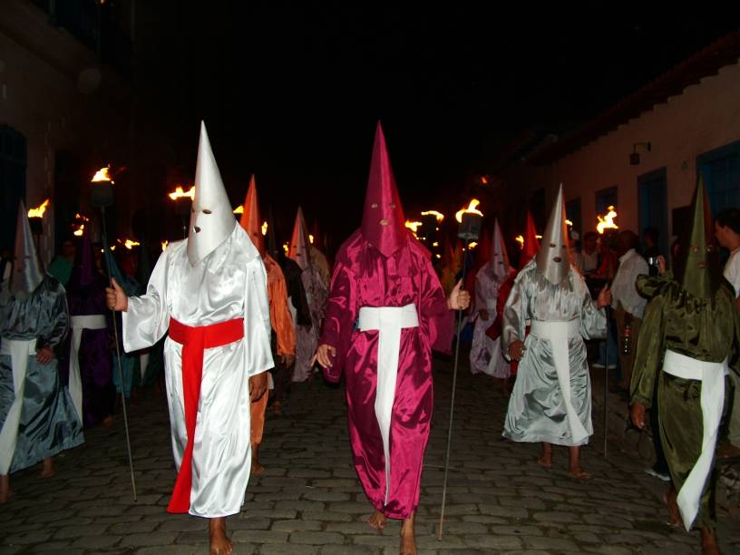 O farricoco de túnica branca é o responsável por carregar o estandarte de Jesus, quando ele é achado. Procissão do Fogaréu, durante a Semana Santa em <a href="https://preprod.viagemeturismo.abril.com.br/cidades/goias/" target="_blank" rel="noopener">Goiás (GO)</a>