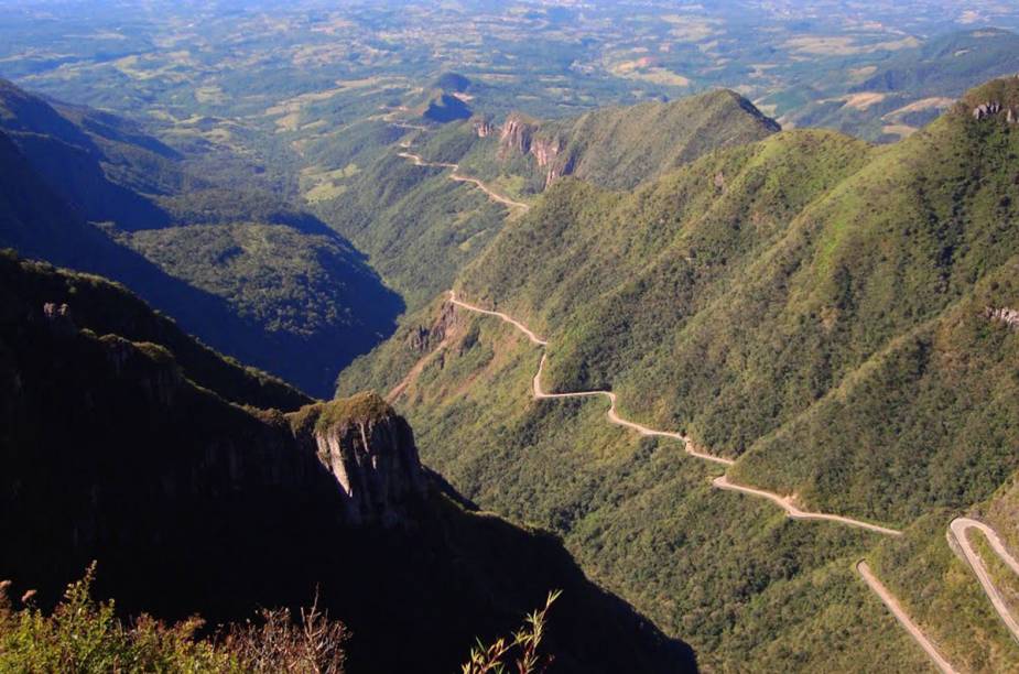 Vista assim do alto, parece um autorama radical pendurado nas    montanhas. E até que é. A estrada da serra do Rio do Rastro, em Santa    Catarina, tem mais de 250 curvas espetacularmente fechadas, em    8 quilômetros de um caminho estreito pra danar. As subidas enfezadas    fervem os carros mais fracotes, mas recompensam quem chega    lá no fm do caminho, a 1 400 metros de altitude, em Bom Jardim da    Serra. Quando a neblina não aparece antes, ver o esplendor daquela    montanha toda provoca até uns surtos ufanistas.