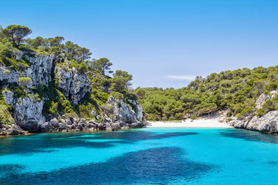 <strong>Cala Macarelleta, <a href="https://viajeaqui.abril.com.br/cidades/espanha-menorca" rel="Menorca" target="_self">Menorca</a>, <a href="https://viajeaqui.abril.com.br/paises/espanha" rel="Espanha" target="_self">Espanha</a></strong>                    O acesso à praia é mais restrito, feito de carro e com uma trilha de dez minutos que antecede sua bela visão. No entanto, os turistas são unânimes quanto ao cenário: um verdadeiro paraíso de areia branca e água turquesa. Também há opções de passeios de barco, perfeitos para casais em lua de mel                    <em><a href="https://www.booking.com/region/es/menorca.pt-br.html?sid=5b28d827ef00573fdd3b49a282e323ef;dcid=4aid=332455&label=viagemabril-as-mais-belas-praias-do-mediterraneo" rel="Veja preços de hotéis em Menorca no Booking.com" target="_blank">Veja preços de hotéis em Menorca no Booking.com</a></em>