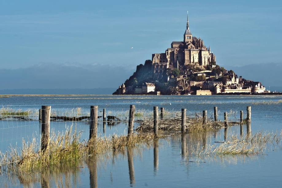 Uma ponte liga o continente ao Mont Saint-Michel. Quando a maré sobe, a força da água é tão grande que ultrapassa o nível da passarela e o local fica totalmente isolado por via terrestre