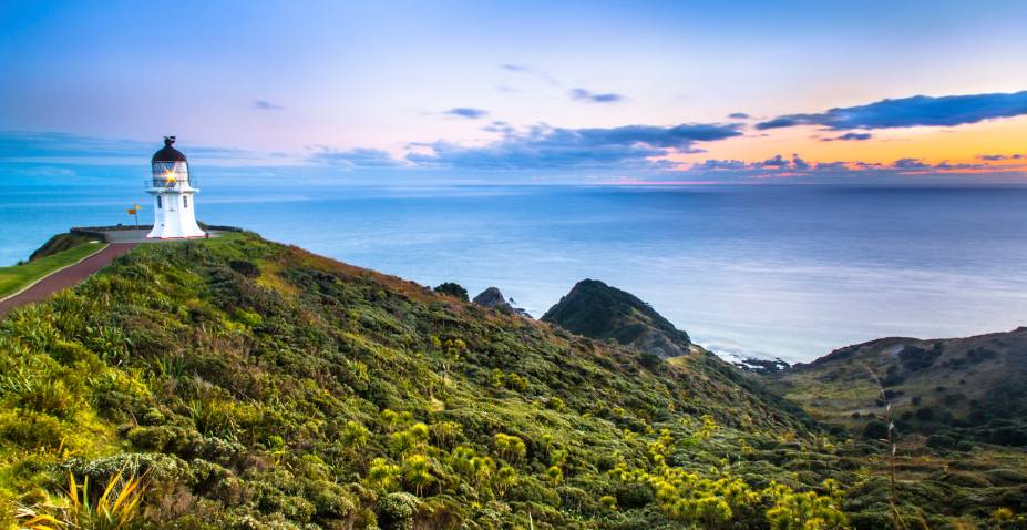 <em><strong>Cape Reinga</strong></em> - O ponto mais ao norte da Nova Zelândia, onde o oceano Pacífico e o mar da Tasmânia se encontram, é um destino turístico imperdível. No caminho ao topo da ilha é possível perceber o estreitamento da terra até o momento em que ambos os oceanos se tornam visíveis do mesmo ponto. Cape Reinga está a cerca de 1.055 quilômetros da capital e pode ser acessada de carro. No local, há um parque com informações históricas sobre a região e um farol que é popular pano de fundo para fotos turísticas