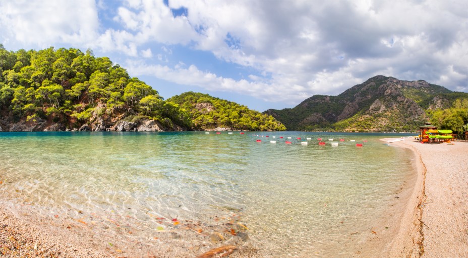 <strong>Oludeniz, Fethiye, <a href="https://viajeaqui.abril.com.br/paises/turquia" rel="Turquia" target="_self">Turquia</a> </strong>                A beleza do lugar é fascinante – tanto que ele já figurou na lista de praias mais lindas do mundo. O cenário da Montanha Babadag, que marca seu entorno, atrai inúmeros praticantes de parapente, que observam a linda paisagem litorânea que a cerca                <em><a href="https://www.booking.com/city/tr/oludeniz.pt-br.html?sid=5b28d827ef00573fdd3b49a282e323ef;dcid=1?aid=332455&label=viagemabril-as-mais-belas-praias-do-mediterraneo" rel="Veja preços de hotéis em Oludeniz no Booking.com" target="_blank">Veja preços de hotéis em Oludeniz no Booking.com</a></em>