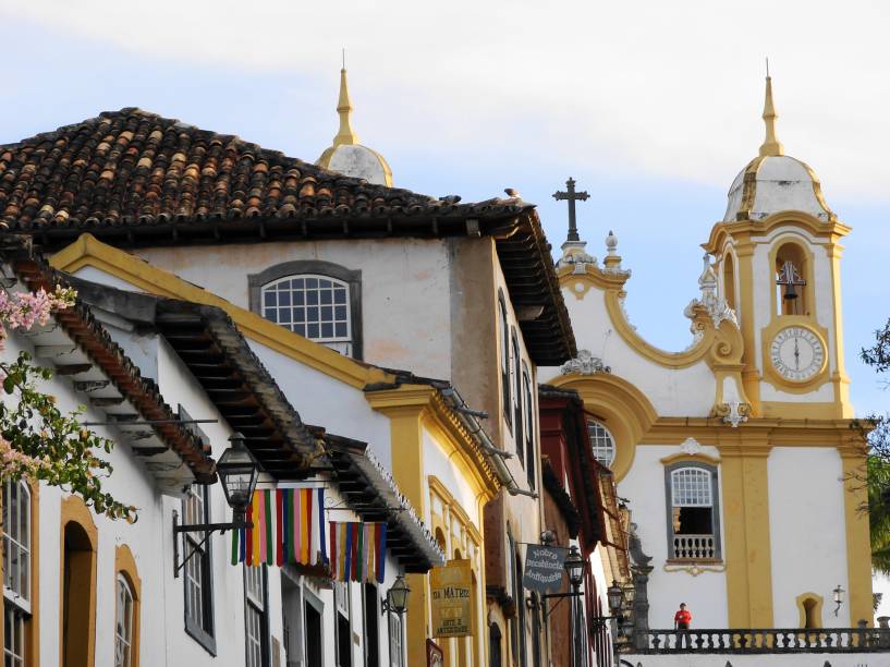 <strong>Tiradentes (MG) </strong><a href="https://viajeaqui.abril.com.br/cidades/br-mg-tiradentes"><strong> </strong></a> Uma das cidades históricas mais bem preservadas do Brasil, conserva até hoje seus ares de interior. Tiradentes tem proporções bem mais modestas que Ouro Preto, excelentes cachoeiras ao redor, gastronomia de primeira qualidade (sete restaurantes premiados pelo Guia Brasil 2015) e um bônus: ainda que esteja na Serra de São José, tem pouquíssimas ladeiras íngremes. Inúmeros ateliês de artistas que trabalham com madeira, estanho, ferro e pedra sabão vendem suas obras nas lojinhas da cidade – e, a pouco menos de uma hora de distância, está Bichinho, uma simpática vila de artesãos. De Tiradentes, sai uma Maria Fumaça turística até São João Del Rey, cidade histórica maior e mais movimentada, um passeio que já vale a pena pela bela paisagem do caminho. Passeios de charrete e a cavalo levam até Bichinho e a outras trilhas pelas montanhas ao redor. <a href="https://www.booking.com/searchresults.pt-br.html?aid=332455&sid=605c56653290b80351df808102ac423d&sb=1&src=index&src_elem=sb&error_url=https%3A%2F%2Fwww.booking.com%2Findex.pt-br.html%3Faid%3D332455%3Bsid%3D605c56653290b80351df808102ac423d%3Bsb_price_type%3Dtotal%26%3B&ss=Tiradentes%2C+Minas+Gerais%2C+Brasil&checkin_monthday=&checkin_month=&checkin_year=&checkout_monthday=&checkout_month=&checkout_year=&no_rooms=1&group_adults=2&group_children=0&b_h4u_keep_filters=&from_sf=1&ss_raw=Tiradentes&ac_position=0&ac_langcode=xb&dest_id=-676172&dest_type=city&place_id_lat=-21.111294&place_id_lon=-44.168297&search_pageview_id=49df83ff14c50046&search_selected=true&search_pageview_id=49df83ff14c50046&ac_suggestion_list_length=5&ac_suggestion_theme_list_length=0" target="_blank" rel="noopener"><em>Busque hospedagens em Tiradentes</em></a>