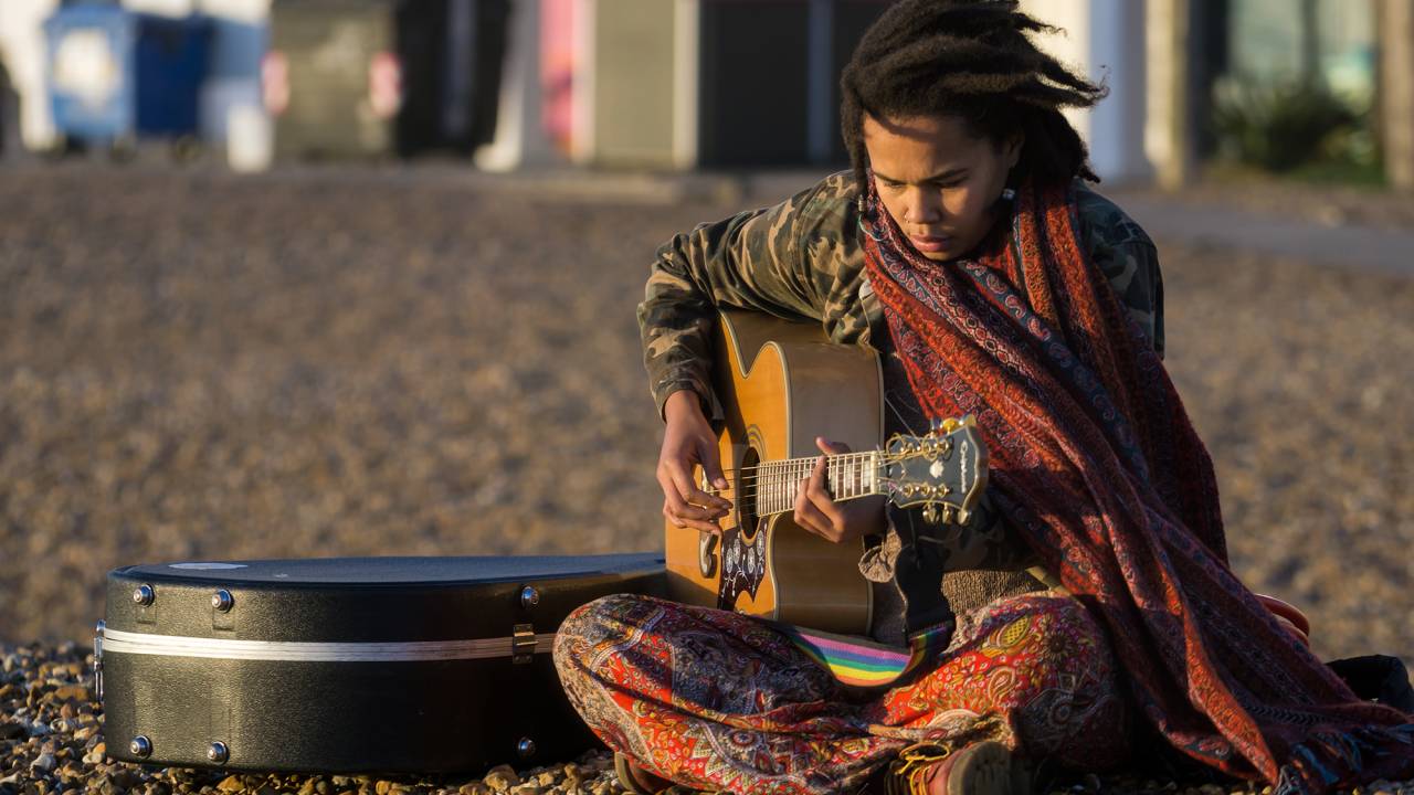 Garota toca violão em praia de Brighton, Inglaterra Flickr