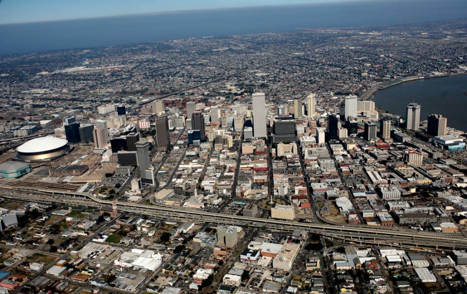 Vista aérea de Nova Orleans, com o estádio Super Dome à esquerda. À direita, uma ponta do rio Mississippi e, no fundo, o lago Ponchartrain