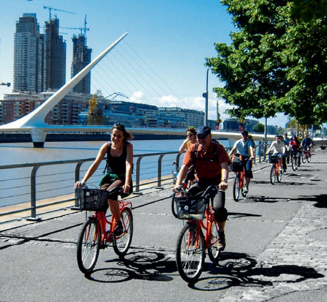 Ciclistas passeiam pelo calçadão cheio de bares, cafés e restaurantes em Puerto Madero, <a href="https://viajeaqui.abril.com.br/cidades/ar-buenos-aires/" rel="Buenos Aires">Buenos Aires</a>