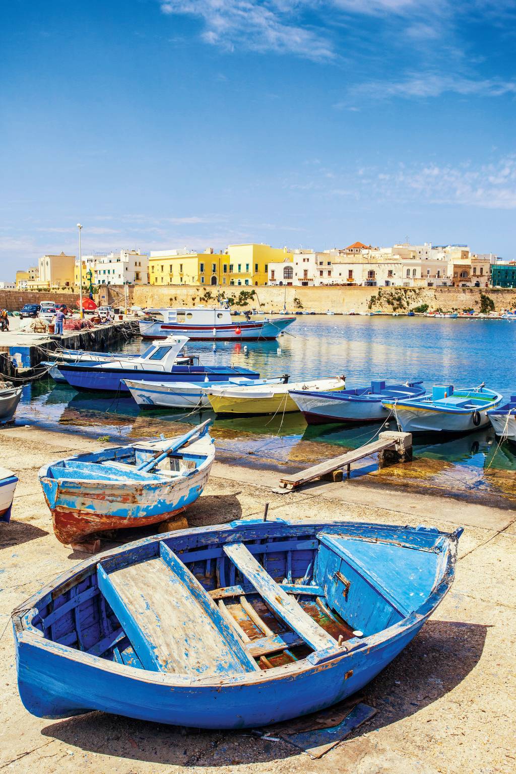 Barcos e fortaleza à beira-mar em Otranto, Puglia, Itália Pequenos barquinhos ancorados em um pequeno porto. Ao fundo, a fortaleza à beira-mar