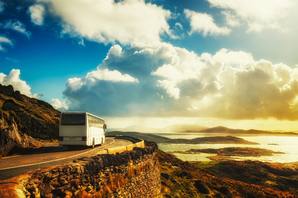 Ônibus faz curva em estrada litorânea no Anel de Kerry, Irlanda, Europa