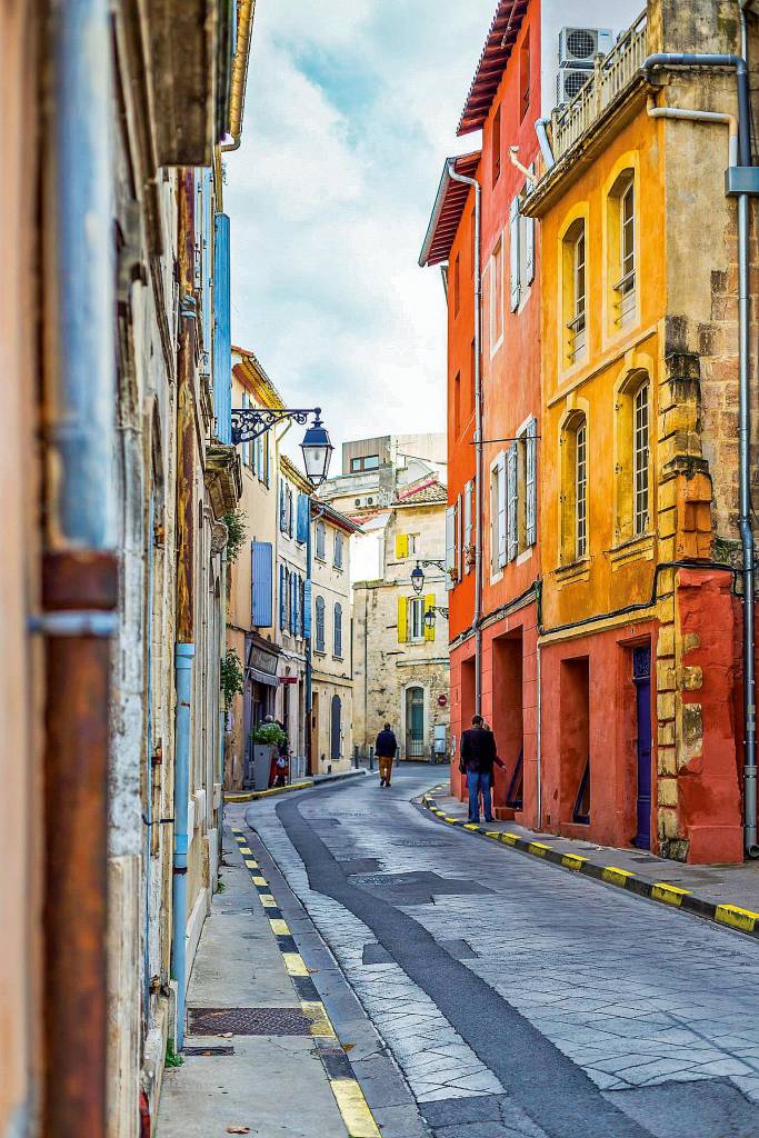 Foto de uma rua de Arles, estreita e cercada por casas de três a quatro andares