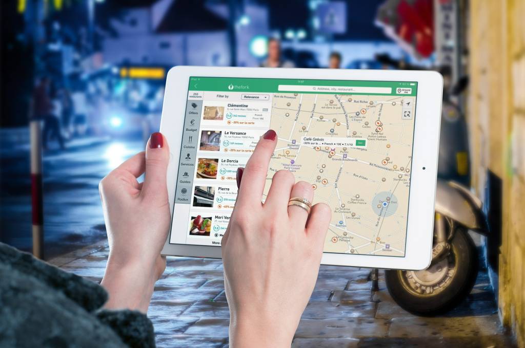 Mulher procura restaurantes em ipad aplicativo