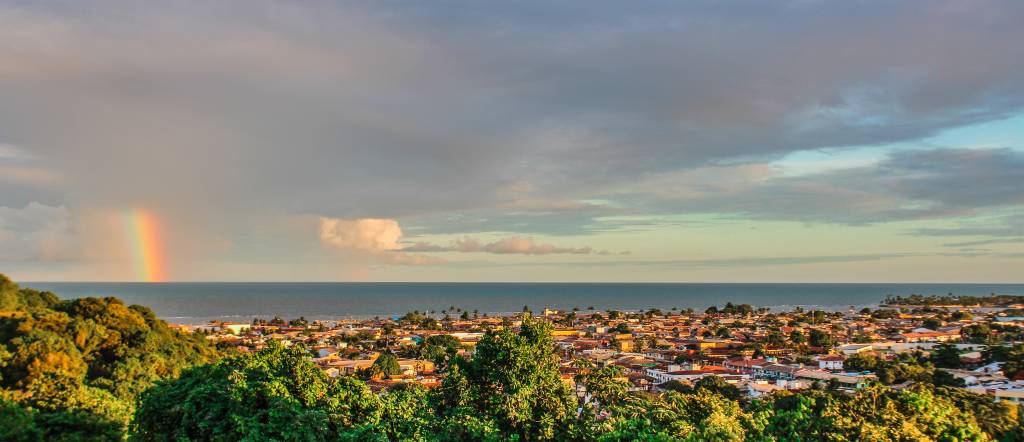 Vista geral do centro histórico de Porto Seguro, cidade do litoral da Bahia, com arco-íris ao fundo, no mar