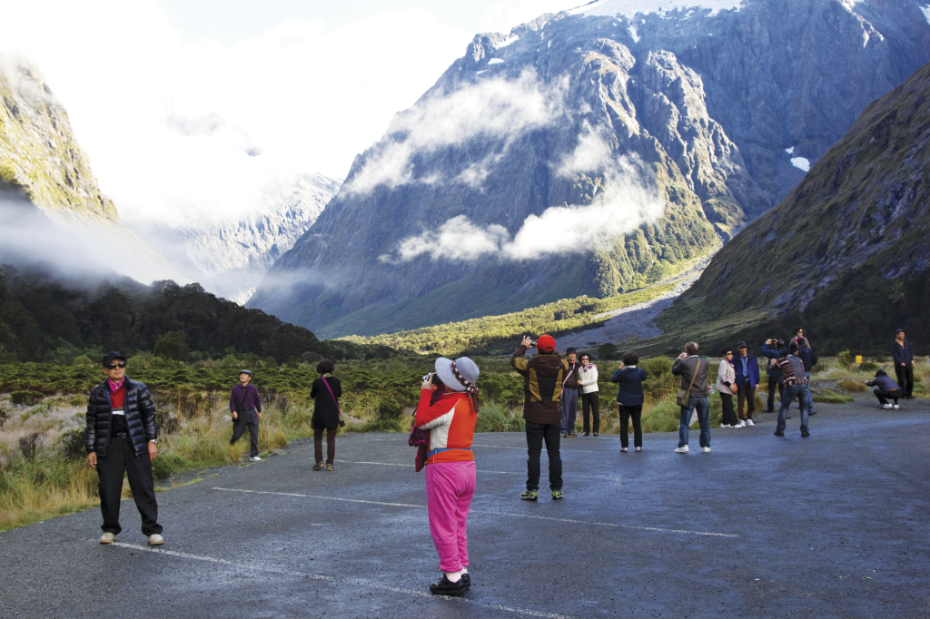 Turistas asiáticos em Milford Sound, Nova Zelândia