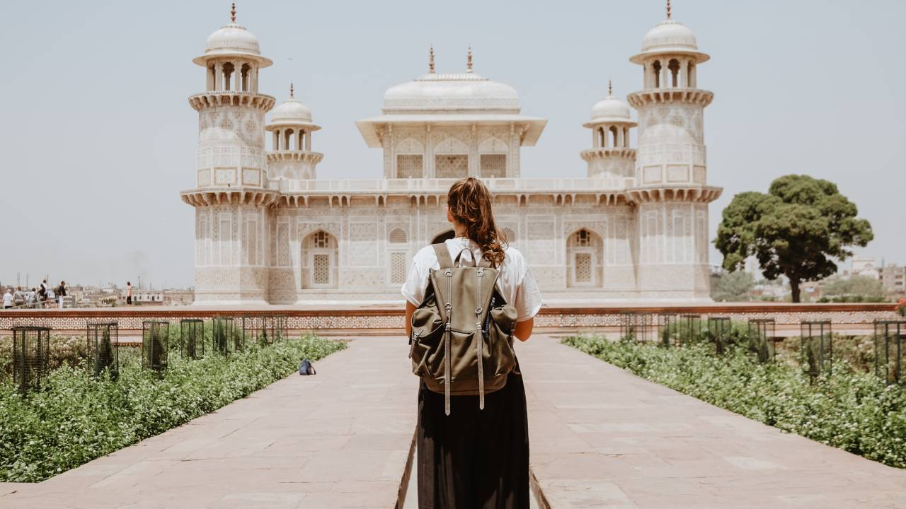 Mulher sozinha em frente ao Tomb of I’timād-ud-Daulah, Agra, Índia