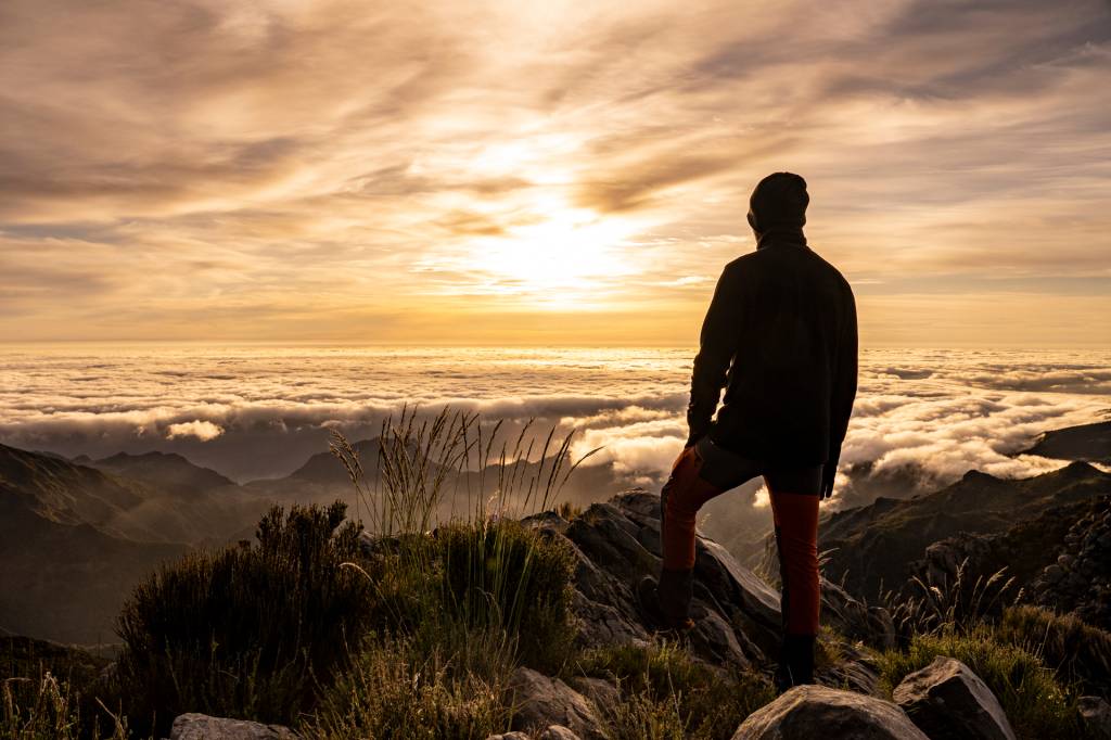 134 Homem observa o sol nascer acima das nuvens no Pico do Areeiro, na Ilha da Madeira