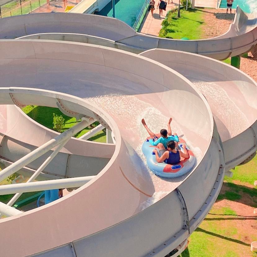 Wet’n Wild – Twister A imagem mostra duas crianças descendo em um escorregador com uma bóia dupla.