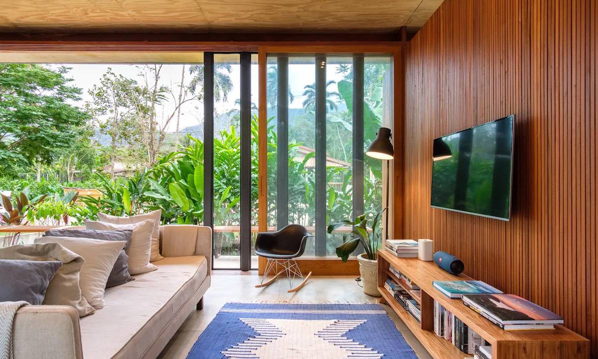 A fotografia colorida mostra uma sala com sofá e televisão