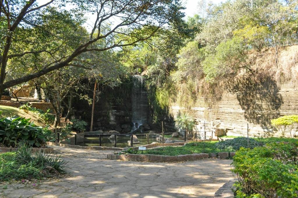 Parque do Varvito, Itu, São Paulo, Brasil A imagem mostra um caminho rodeado de natureza e com uma pedra em camadas, ou com riscos