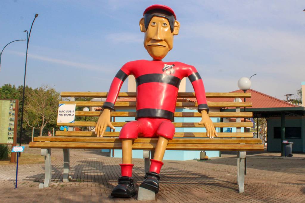 Praça dos Exageros, Itu, São Paulo, Brasil A foto mostra uma escultura gigante de um homem vestindo uma camisseta vermelha e preta do time ituano