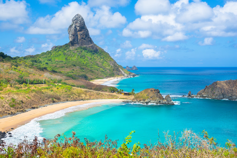 Beautiful view of Conceicao and Middle Beaches with Peak Hill (Morro do Pico) in the brackground, Fernando de Noronha Island – Brazil A calmaria do mar de Noronha ganha um toque especial quando explorada a bordo da Va’a