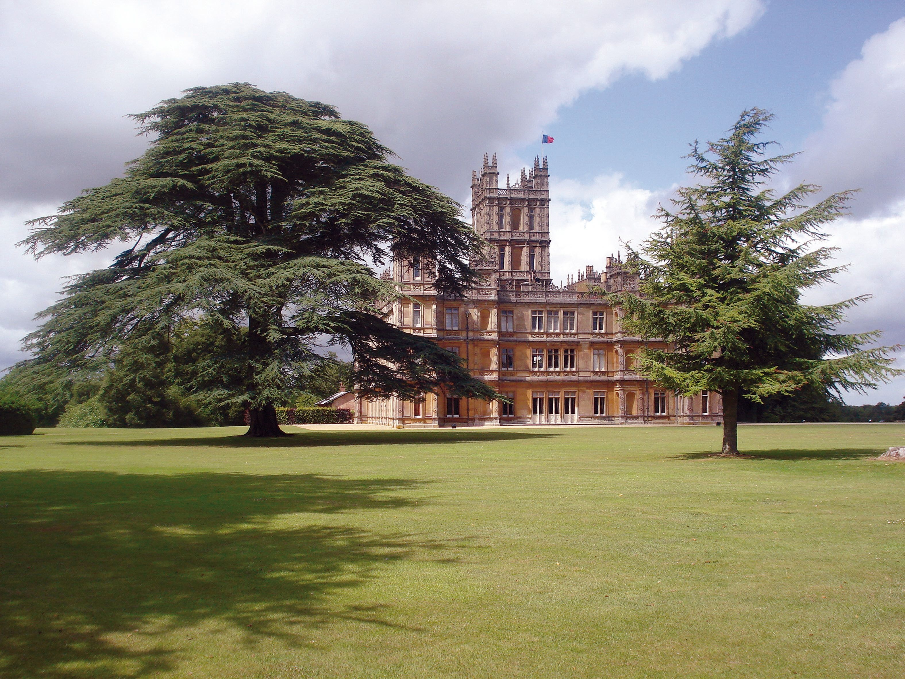 The grounds of a large stately castle and its manicured lawns and gardens.